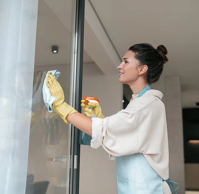 Mujer limpiando cristal